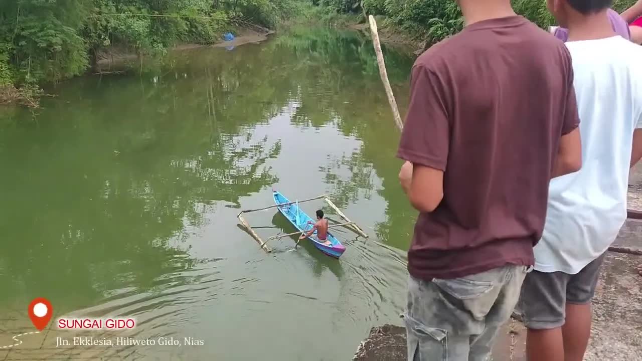 Menyaksikan penurunan perahu kayu di sungai desa